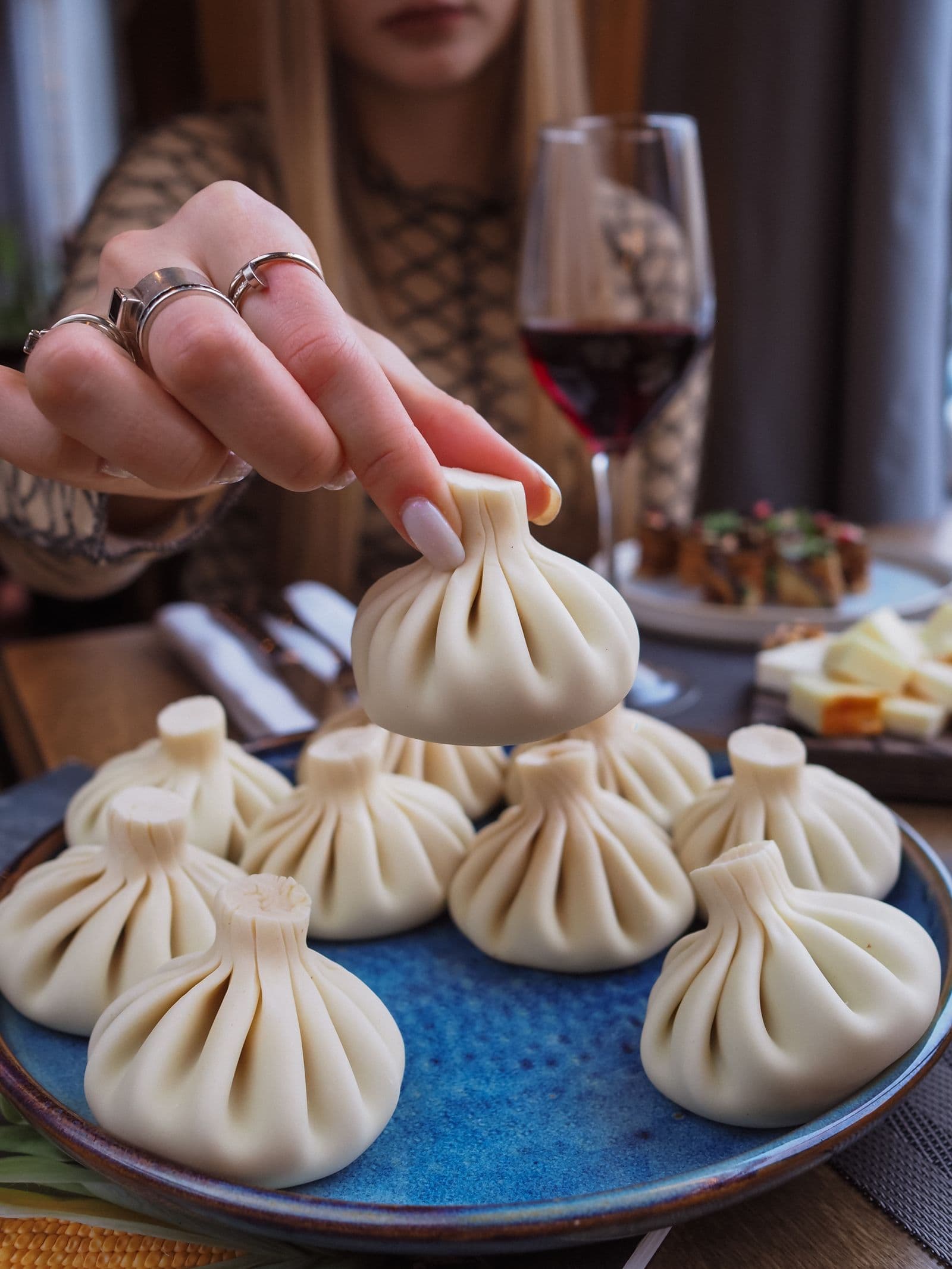 Plate of khinkali dumplings served with a glass of Georgian amber wine