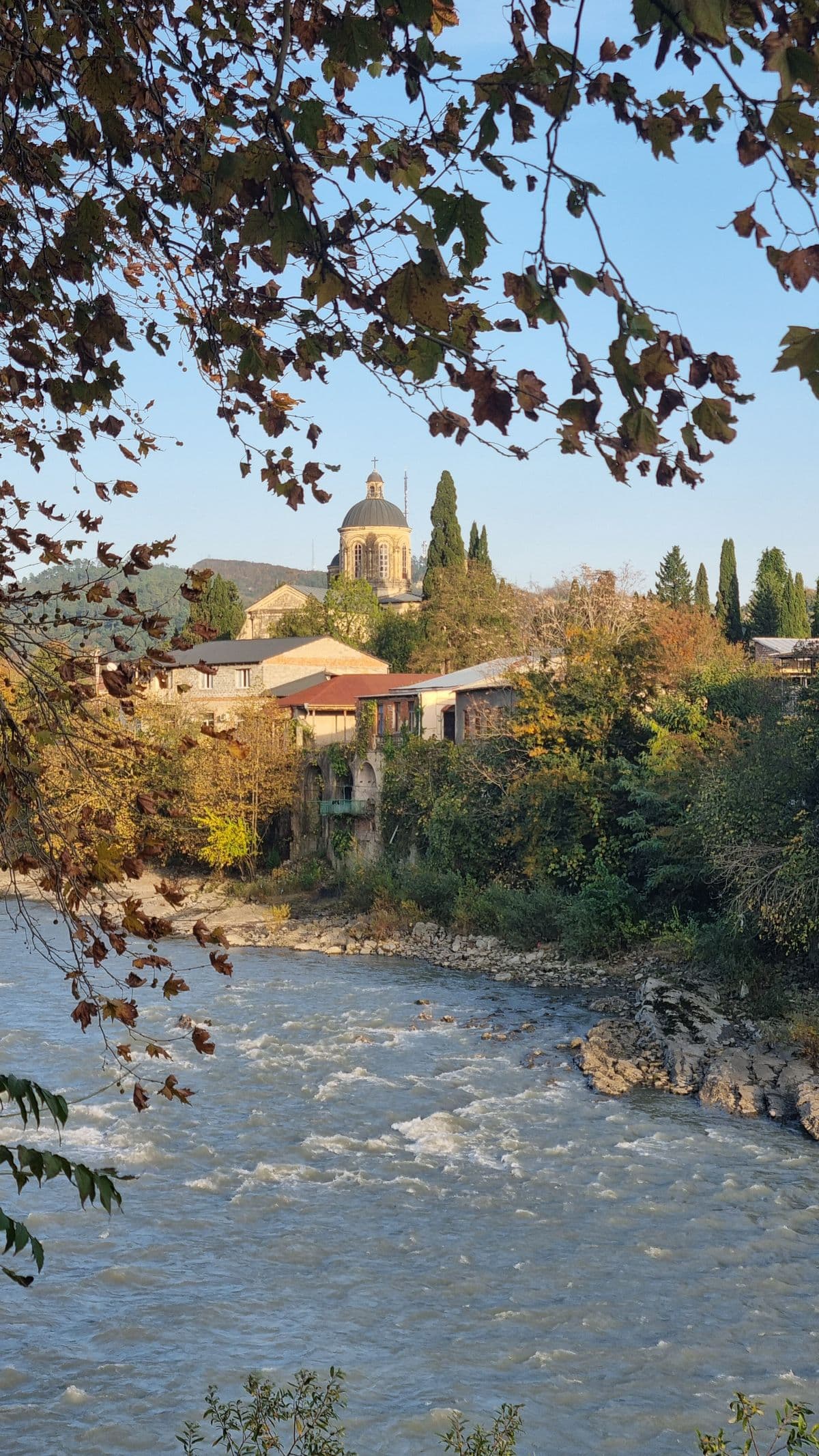 The Rioni river running through Kutaisi past rooftops and wooded hillsides
